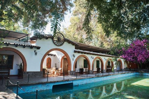 uma casa com uma piscina em frente em Hotel Majoro em Nazca