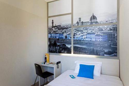 a room with a bed and a picture of a city at B&B Hotel Firenze Novoli in Florence