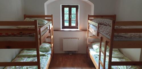 two bunk beds in a room with a window at Dom Pristava in Jesenice