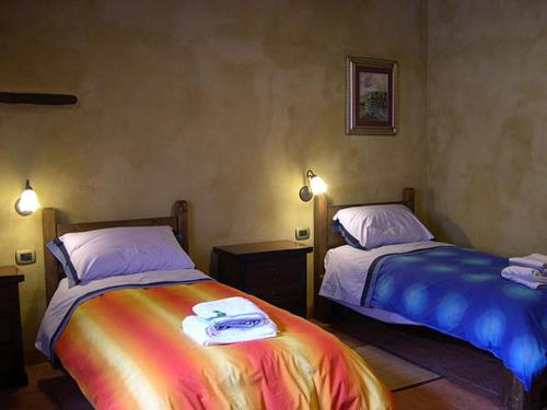 1 dormitorio con 2 camas y sábanas coloridas en Borghetto Di San Filippo en Barberino di Val dʼElsa