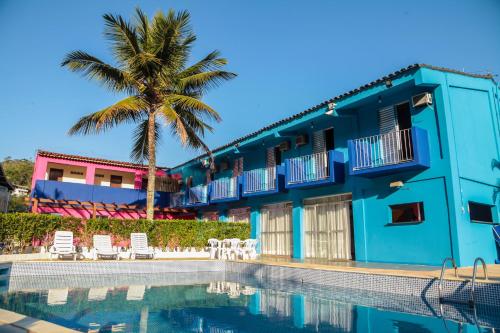a large blue and white house with a pool at Hotel Costa Azul in Ubatuba