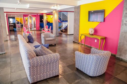 a lobby with couches and a colorful wall at MOVA - Hotel Costa Azul in Ubatuba