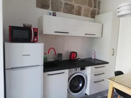 a kitchen with a refrigerator and a washing machine at Zanicovo beach apartment in Komiža