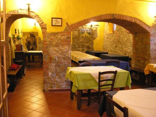 a restaurant with tables and chairs and a stone wall at Borghetto Di San Filippo in Barberino di Val dʼElsa
