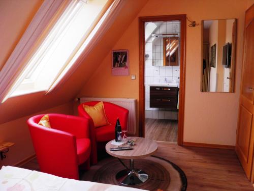 a room with red chairs and a table and a window at Gästehaus Ziemann in Friedrichstadt