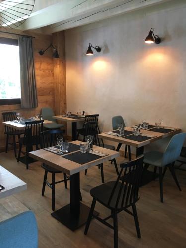 uma sala de jantar com mesas e cadeiras de madeira em Hôtel le Christiania em Arêches