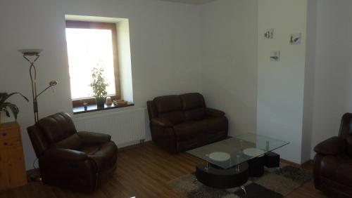 a living room with two chairs and a glass table at Penzion Lipina in Slatiňany