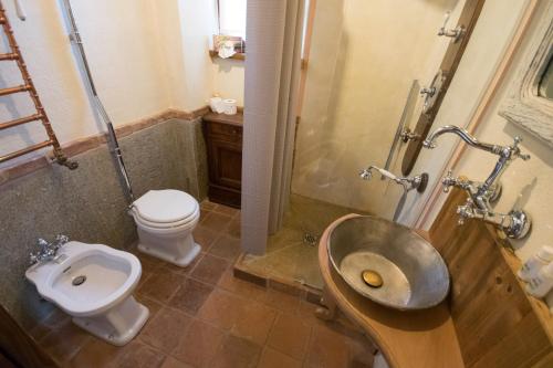 
a bathroom with a toilet and a sink at Agriturismo Il Sogno Della Vita Resort in Peveragno
