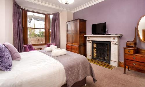 a bedroom with a bed with a fireplace and a television at Highfield House in Ambleside