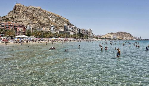 un grupo de personas en el agua en una playa en Apartamentos Boutique Villavieja, en Alicante
