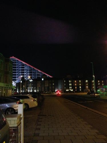 a building at night with cars parked in a parking lot at Clifton Court Hotel in Blackpool