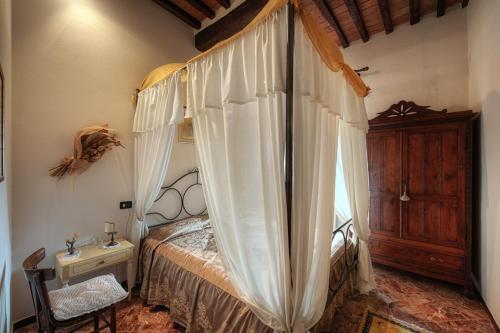 een slaapkamer met een hemelbed en een houten dressoir bij Casa Di Castello in Castelmuzio