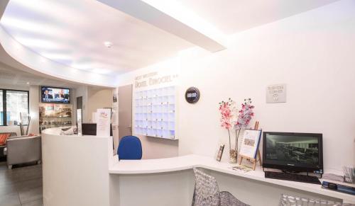 a waiting room with a computer on a desk at Privilège Hôtel & Apparts Eurociel Centre Comédie in Montpellier