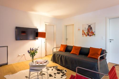 a living room with a couch and a tv at Legendär Zermatt in Zermatt
