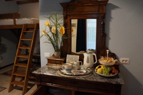 una mesa con un bol de fruta y un espejo en LA BRIGATA APARTMENTS Suite Room en Cavallino-Treporti