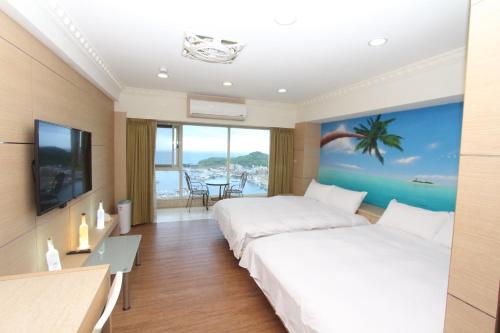 una camera d'albergo con due letti e una televisione di Sea Keelung 61 a Keelung