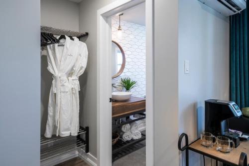 a dressing room with a mirror and a closet at Square Victoria Maison Hôtelière in East Angus