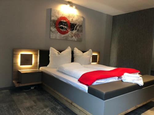 ein Schlafzimmer mit einem Bett mit einer roten Decke darauf in der Unterkunft Moderne Pension vonBartsch mit Ladestation in der sächsischen Schweiz in Struppen