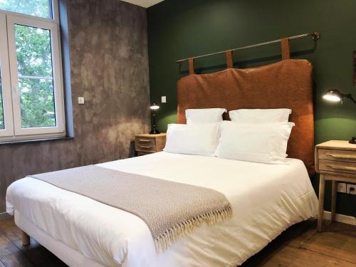 1 dormitorio con 1 cama grande con almohadas blancas en Nuit en Ville Pompidou Lille La Madeleine, en La Madeleine