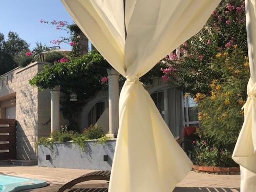 a close up of a white umbrella in front of a house at Villa Bougenvilia Tomas in Tučepi