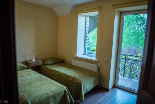 duas camas num quarto com duas janelas em Prie upes em Kunioniai