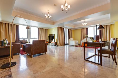 a living room filled with furniture and a large window at Abidos Hotel Apartment Dubai Land in Dubai