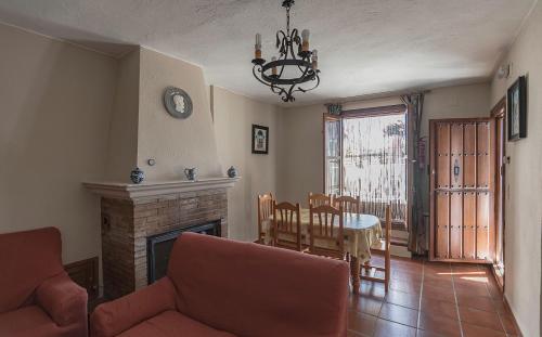 sala de estar con chimenea y comedor en Apartamentos Rurales Las Chimeneas, en Capileira