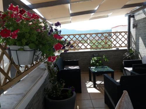 a balcony with plants and chairs and a table at Green House in Néa Péramos
