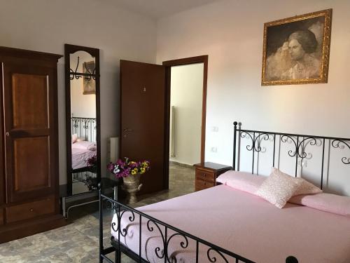 莫利內拉的住宿－Locanda Al Cavaliere，一间卧室配有一张带粉色床单和镜子的床