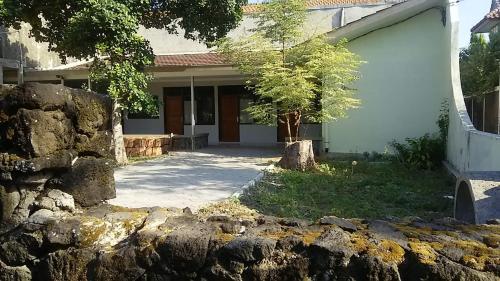 a house with a stone wall in front of it at Srikaloka 12 Kostel - for Female and Couple in Yogyakarta