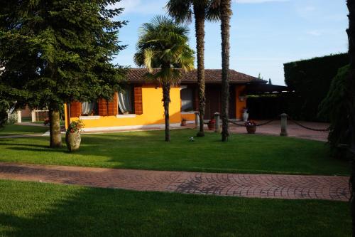 dom z palmami i zielonym trawnikiem w obiekcie LA BRIGATA APARTMENTS Suite Room w Cavallino-Treporti