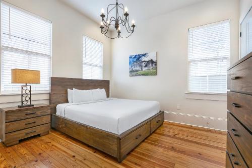 a bedroom with a bed and a chandelier at Fabulous Cottages with City Views in New Orleans