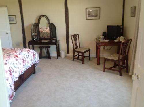 a bedroom with chairs and a bed and a desk at Baron's Grange in Iden
