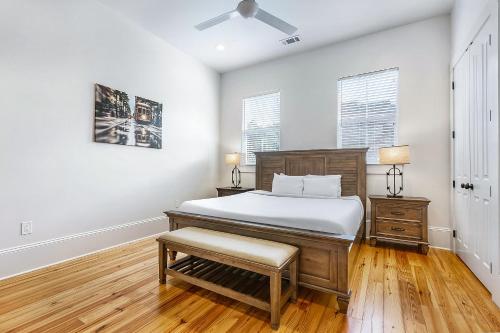 a bedroom with a bed and a chair and windows at Hosteeva 3 BR Cottage Close to St Charles 5 m Ride to FQ in New Orleans
