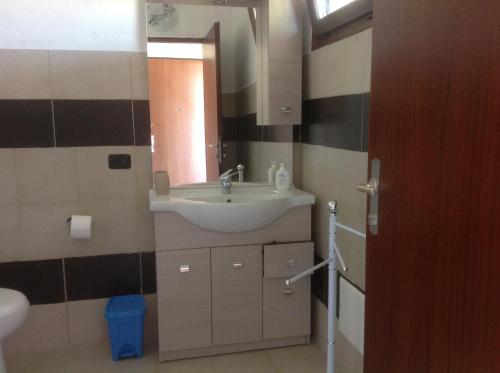 een badkamer met een wastafel en een spiegel bij Il podere in Roccella Ionica