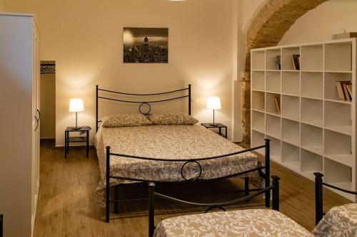 a bedroom with a bed and two tables and two lamps at Casa Concerie Quattro in Sulmona