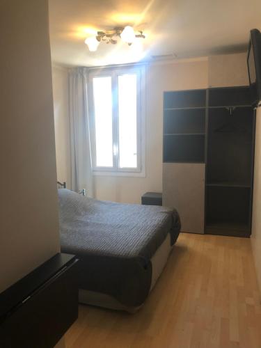 a bedroom with a bed and a window at Hôtel Le Lys d'Or in Vauvert