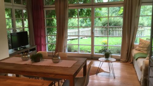 a living room with a table and large windows at Landhaus Roidergütl in St. Wolfgang
