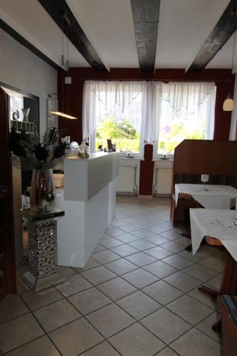 a large room with a kitchen and a table at Hotel & Restaurant Blume in Wolfsburg