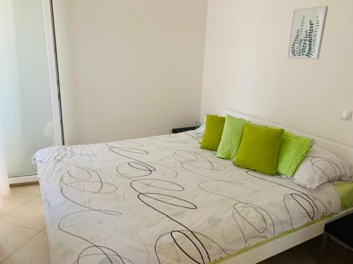 诺瓦利娅Josip Modern Apartment Novalja的卧室里有一张床，上面放着绿色枕头