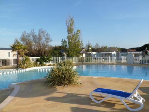 a blue chair sitting next to a swimming pool at Camping Rives des Corbières in Port Leucate