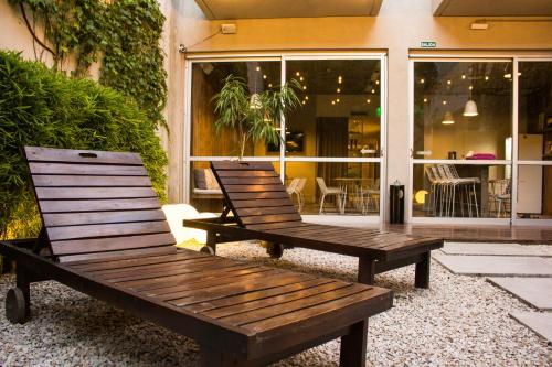 two wooden benches sitting in front of a building at Lemon Suites in Buenos Aires