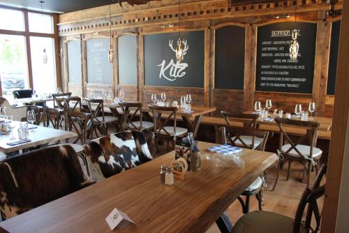 a restaurant with wooden tables and chairs in a room at Hotel Brunnthal in Brunnthal