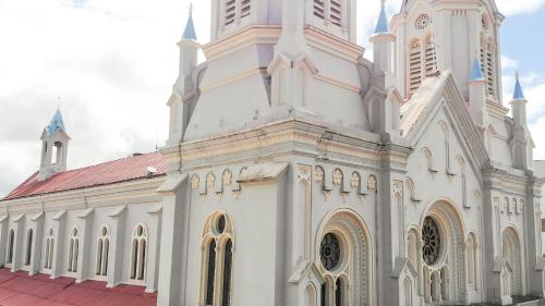 a large white church with a red roof at Hotel La Orquidea in Cuenca