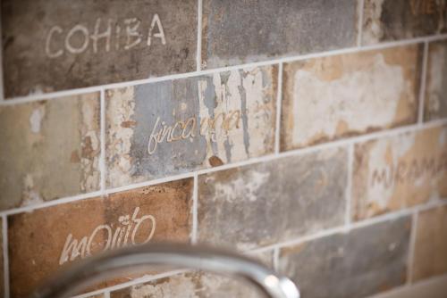a bathroom tile wall with writing on it at Nikolas place in Oítilon