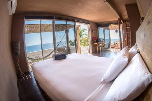 a bedroom with a bed with a view of the ocean at Villa Casa Blanca del Faro in Zipolite