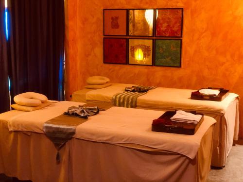 a room with three beds with towels on them at Shanghai Mansion Bangkok in Bangkok
