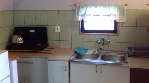 a small kitchen with a sink and a window at Cichy Zakątek Junoszyno in Junoszyno