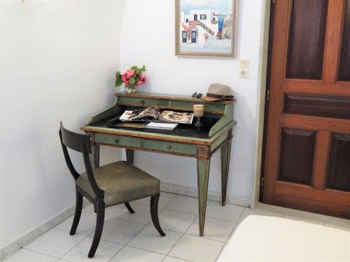 a desk with a chair next to a door at Le Petit Greek in Fira