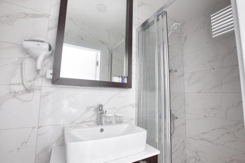 a white bathroom with a sink and a mirror at Siete Hotel in Antalya